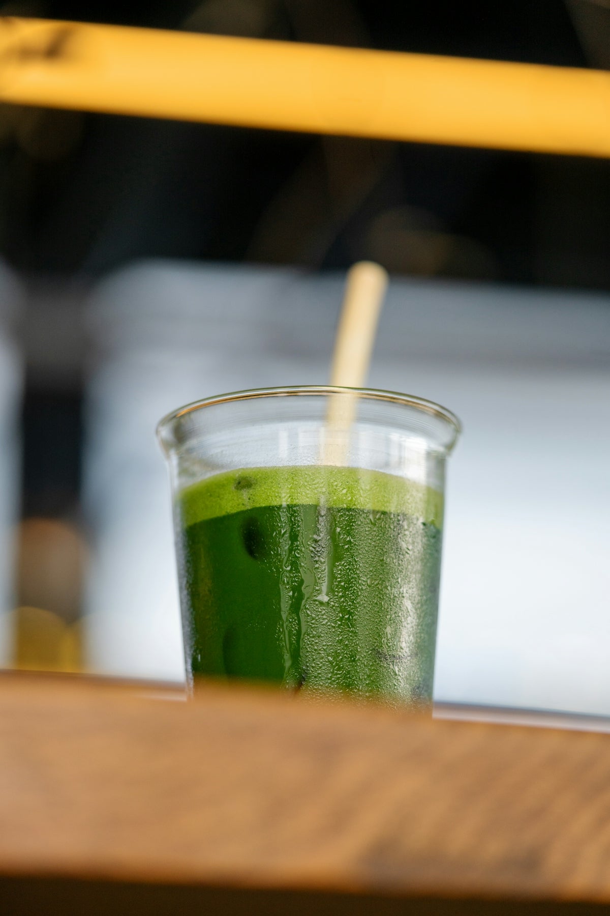 a glass of green juice sitting on a table