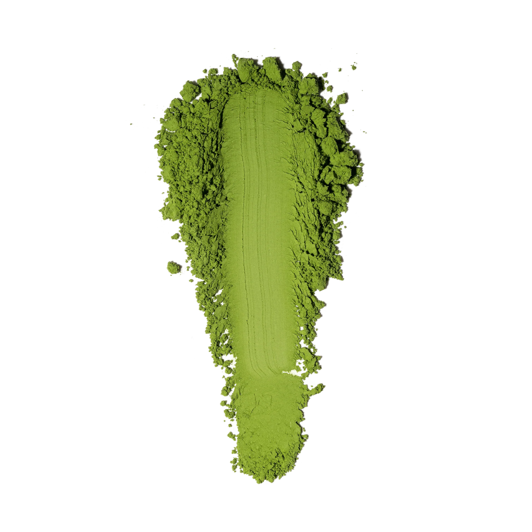 Vivid green ceremonial grade matcha powder in a smooth scoop on a white background