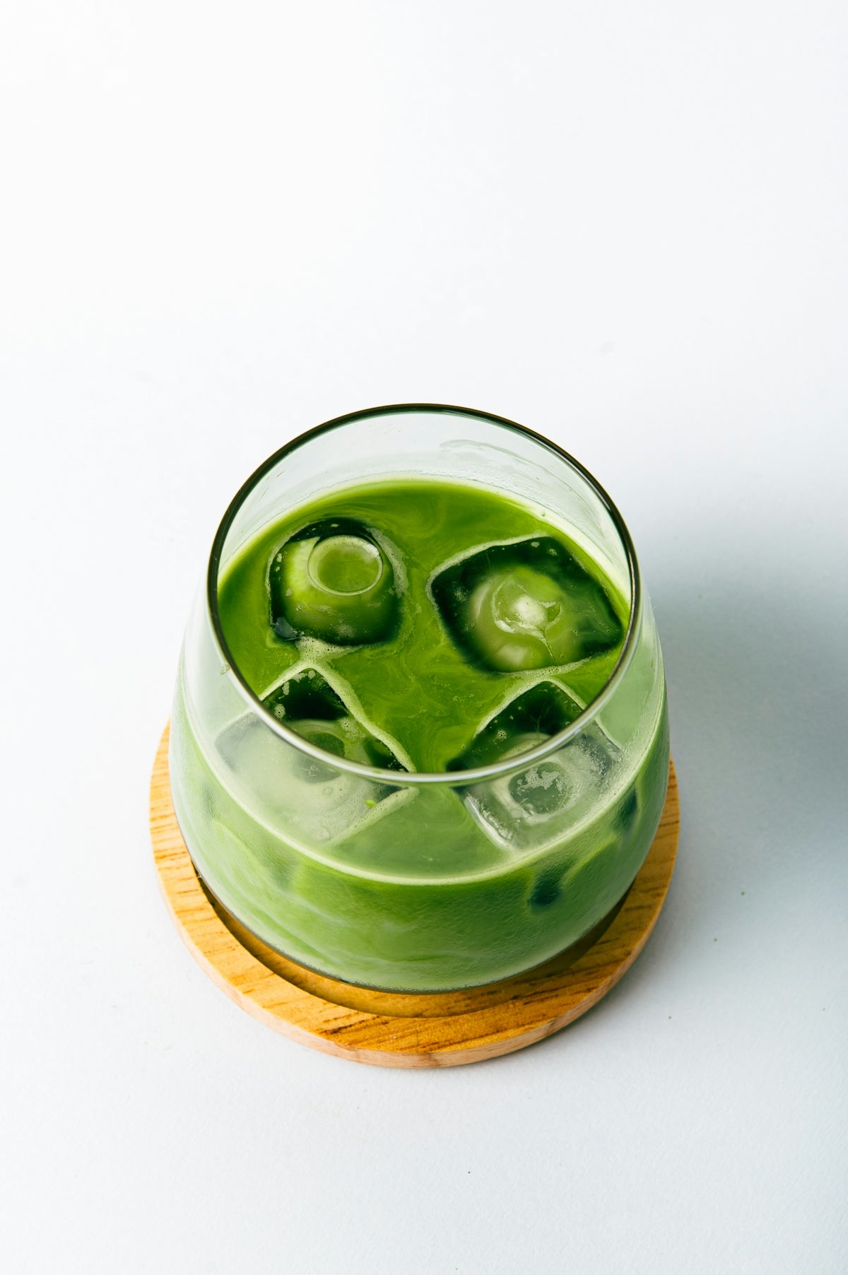 a green drink with ice cubes in it