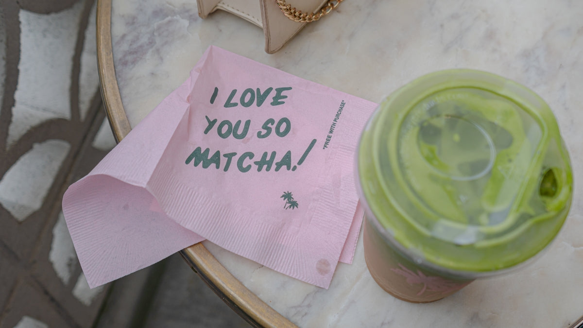 A cup of coffee with a note attached to it