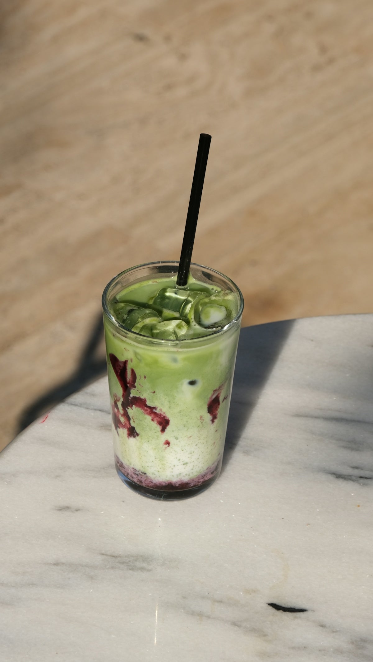 Matcha drink with ice and a straw.